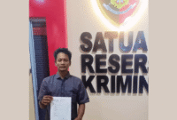 Andri Fitrio (35) tunjukan bukti laporannya setelah dirinya selesai melapor di Polres Labuhanbatu.