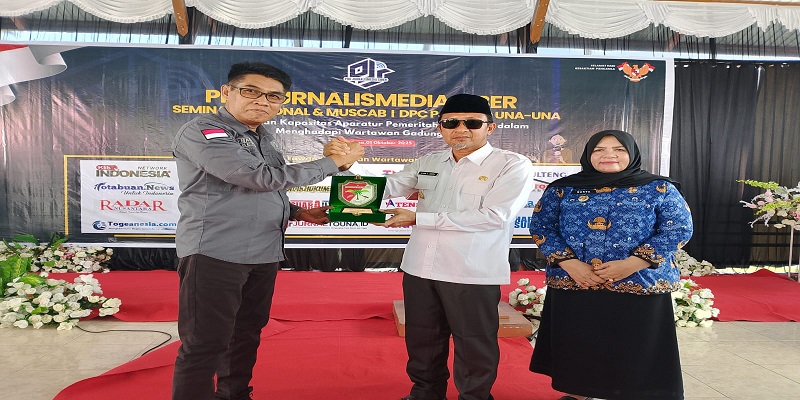 Ketua Umum Pro Jurnalismedia Siber (PJS) Mahmud Marhaba menyerahkan cinderamata kepda Bupati Tojo Una- una Ilham Lawidu yang didampingi wakil bupati Hj Surya. (ist)