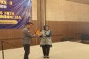 PJS menyerahkan penghargaan kepada Kepala Kantor Wilayah Direktorat Jenderal Pemasyarakatan Bangka Belitung, Ade Agustina, SH., MH., salah seorang toko penerima Award pada Muns III PJS di Hotel Acacia Jakarta, (21/7/26). 